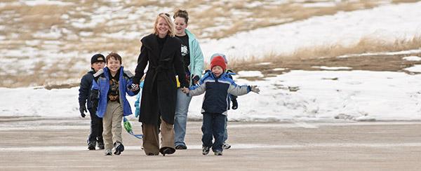 A student volunteer and a parent guide a group of children on a walk at the Child Development Center Laboratory
